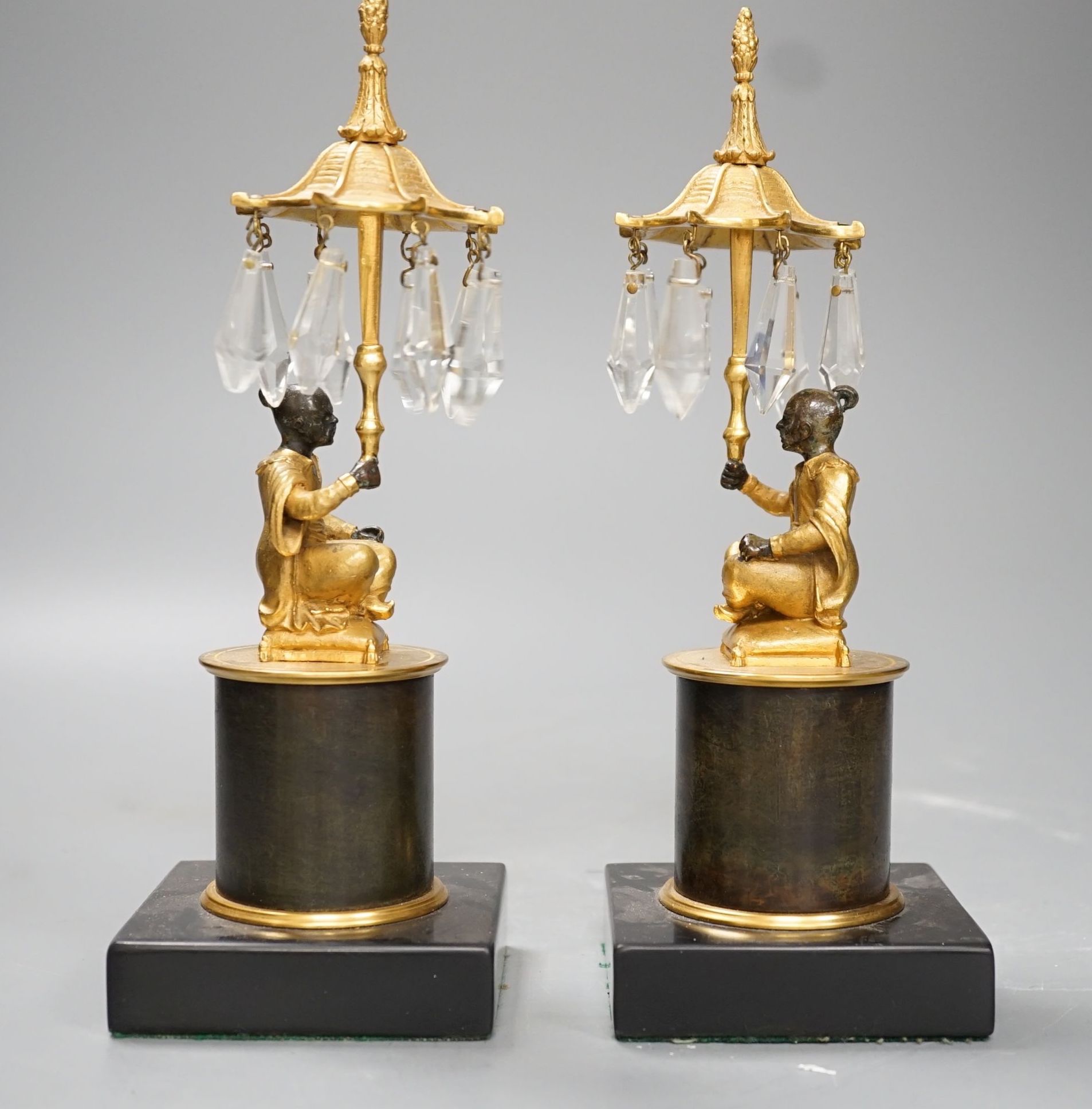 A pair of Louis XVI style bronze chinoiserie lustres depicted plinth seated gentleman bearing umbrella lustre drops - 23cm tall